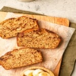 Slices of banana bread on a cutting board lined with parchment paper.