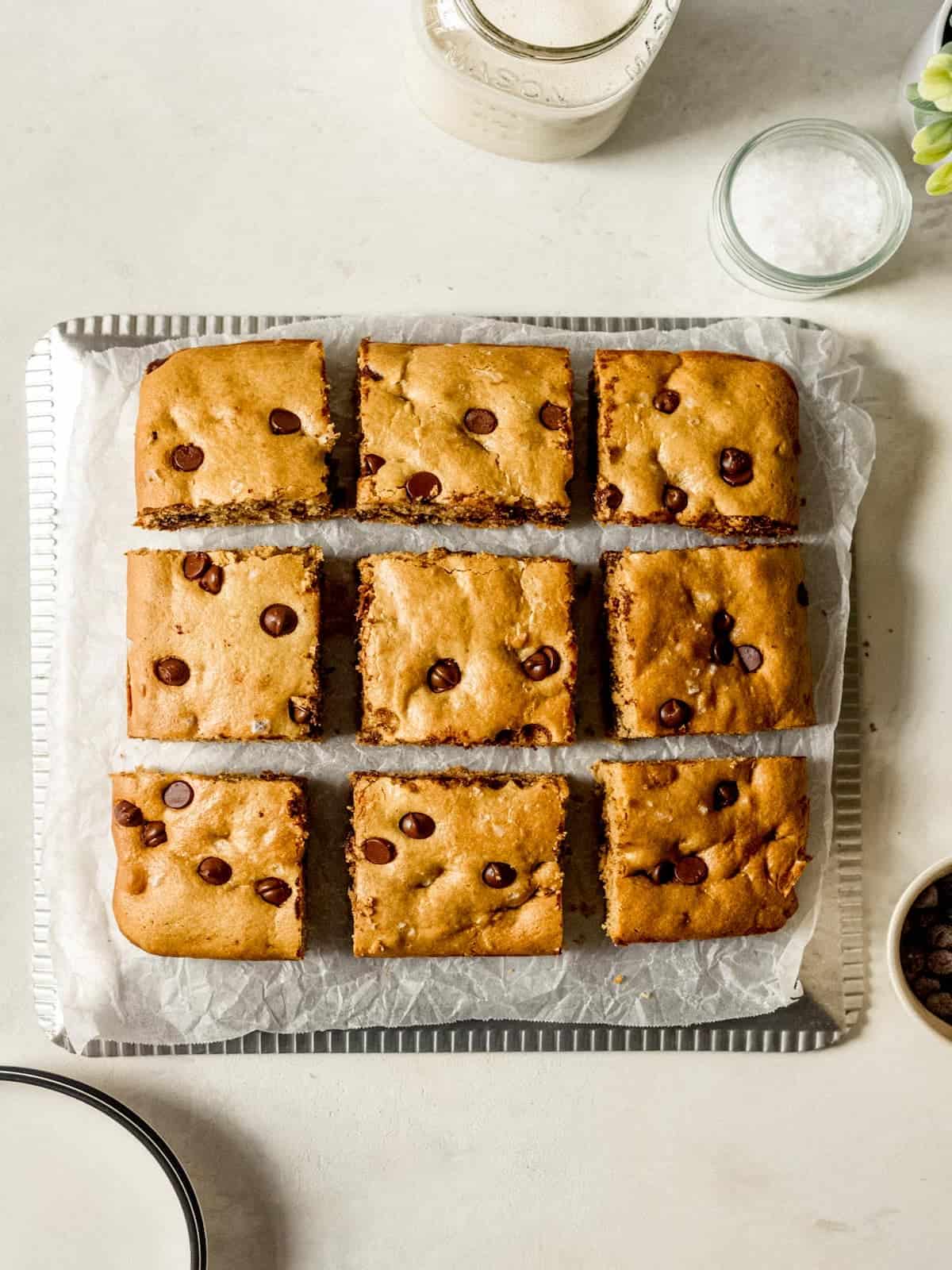 Chocolate chip cookie bar squares on wax paper.