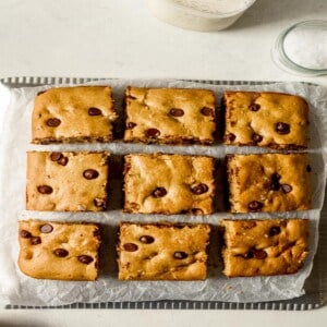Chocolate chip cookie bar squares on wax paper.