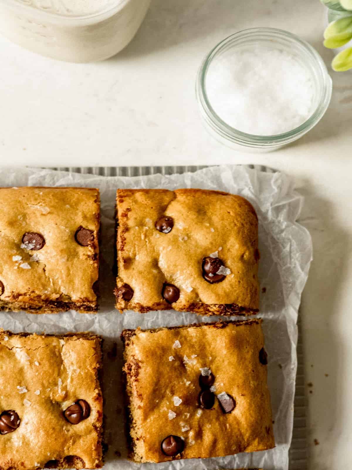 Chocolate chip cookie bar squares on wax paper.