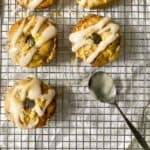 donuts on a cooling rack with a metal spoon