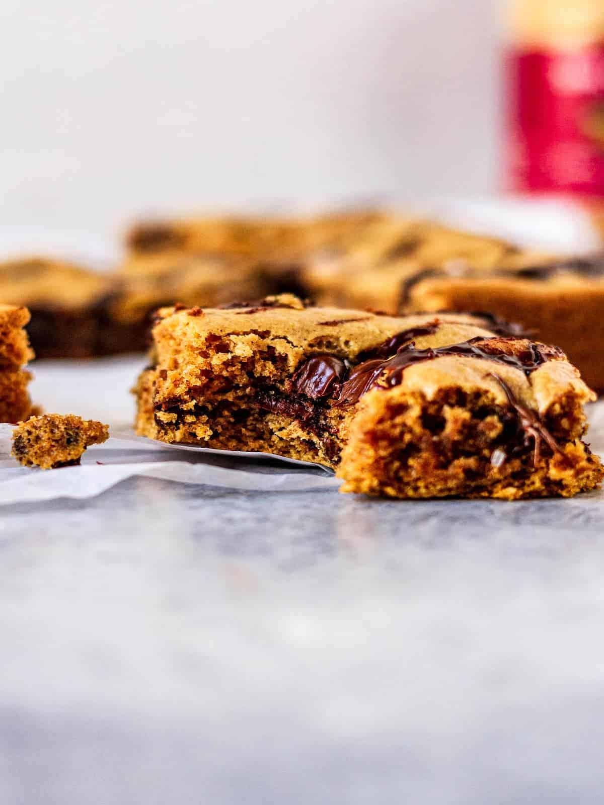 A bite taken out of a chocolate chip peanut butter cookie bar.