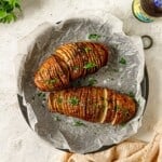 Hasselback potatoes next to two beer bottles.