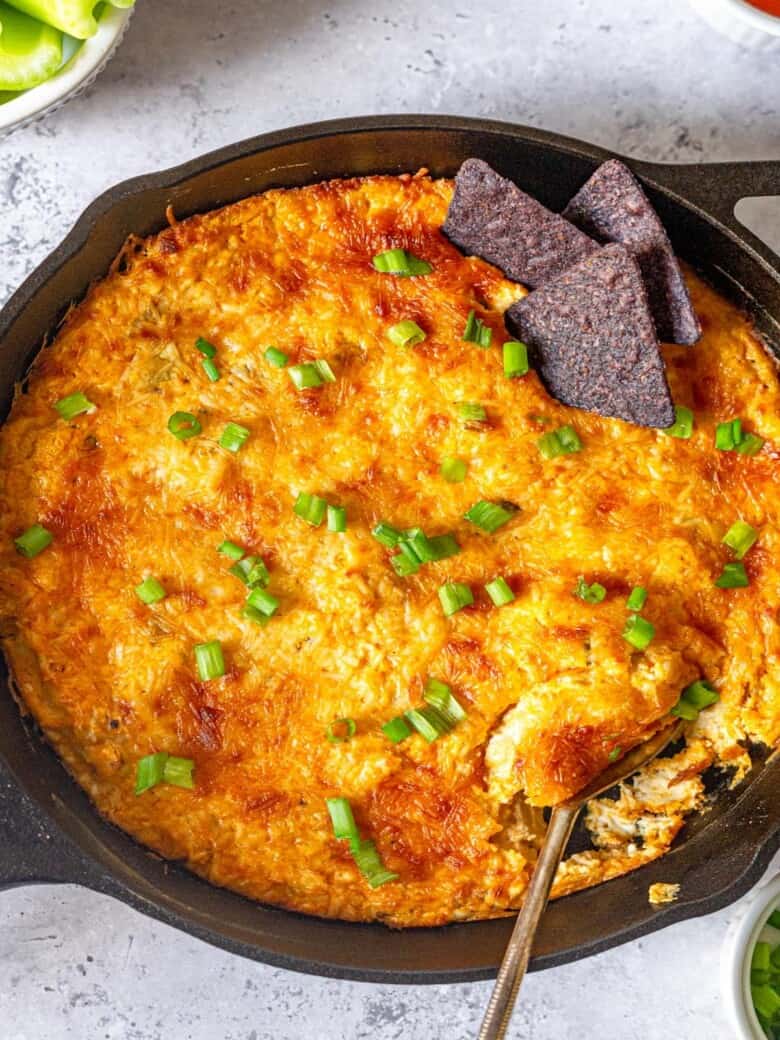 A cast iron pan filled with dip on a gray surface.