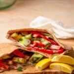 pita pocket gyros on a cutting board with lemon wedges