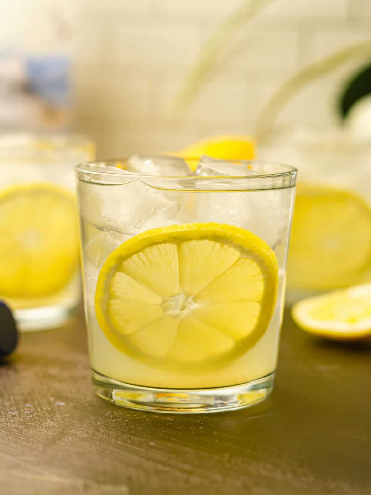 A vodka sour in a glass with ice and a lemon slice.