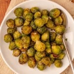 Brussels sprouts with a serving spoon on a plate.