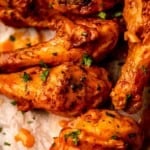 Buffalo chicken drumsticks topped with parsley.