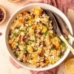 Salad tongs in a bowl of cold quinoa salad.