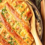 A pot pie with a wooden spoon digging in.