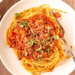 A plate of spaghetti with sauce.