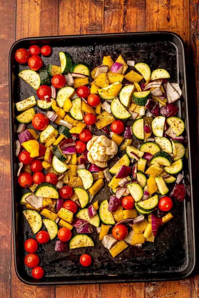 Vegetables and garlic on a pan before roasting.