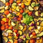 Sheet pan full of roasted Italian veggies with fresh basil.