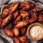 Dry rub wings on a platter with blue cheese dressing.