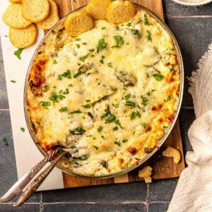 Crab spinach artichoke dip on a cutting board.