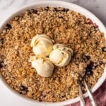 Berry crisp topped with vanilla ice cream.