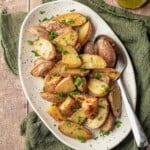 A spoon scooping potato salad on a plate.