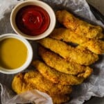 Fried chicken tenders with ketchup and honey mustard.