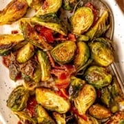 Bacon and brussels sprouts on a plate with a spoon.