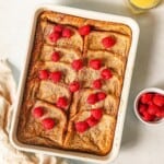 French toast bake topped with raspberries in a baking pan.