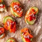 Smoked salmon canapés on wax paper.