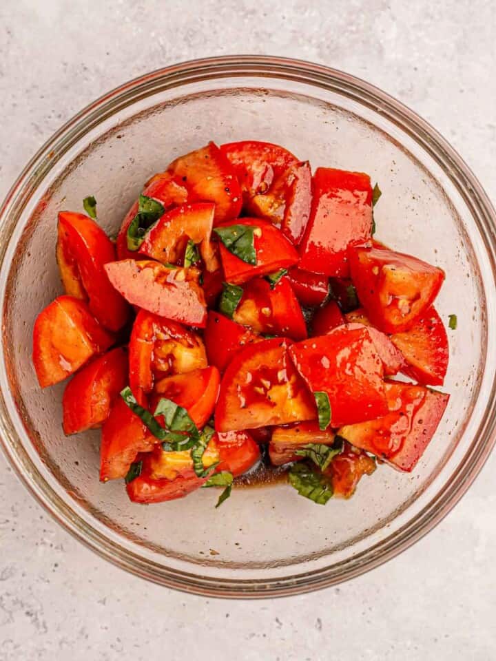 Tomatoes in a bowl with basil.
