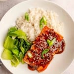 A bowl of rice, bok choy and teriyaki salmon.