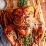 Roasted turkey with herbs on a cutting board.
