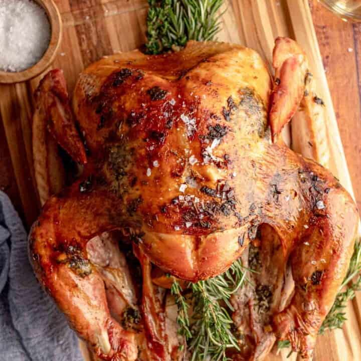 Roasted turkey with herbs on a cutting board.