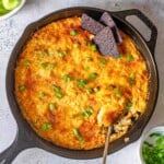 Buffalo chicken dip in a pan topped with scallions.