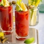 Virgin bloody marys garnished with lemon and lime wedges.