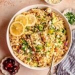 A bowl of lemon orzo salad topped with lemon slices.