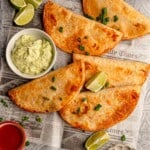 Baked buffalo chicken tacos with a bowl of avocado yogurt sauce.