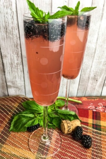 Blackberry cocktail in glass with blackberries and mint.