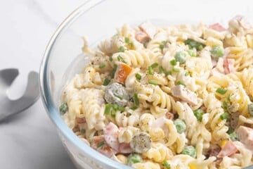Creamy pasta salad in a clear bowl.