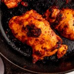 Harissa chicken thigh on a skillet.