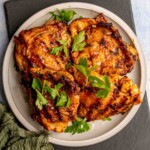 Grilled chicken thighs topped with parsley.