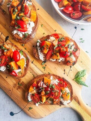 Peach, tomato and burrata bruschetta on crispy bread.