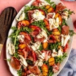 Arugula topped with peaches, proscuitto and burrata cheese.