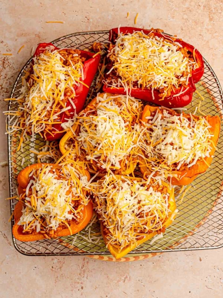 Stuffed peppers topped with shredded cheese.