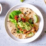 Cilantro lime chicken taco topped with salsa and guacamole.