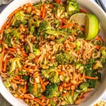 Cold noodle salad topped with lime wedges.