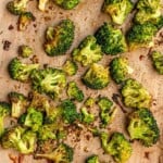 Roasted broccoli on parchment paper.