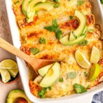 Spoon scooping chicken enchiladas.