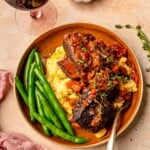 Red wine braised short ribs on a plate with green beans.