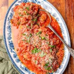 A blue and white platter serving chicken cacciatore.