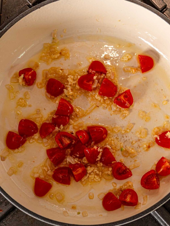 Tomatoes and minced garlic sautéing in olive oil with diced shallots.