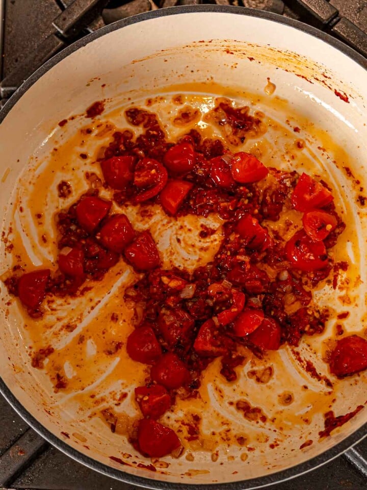 Tomatoes and tomato paste cooking with garlic and red pepper flakes.