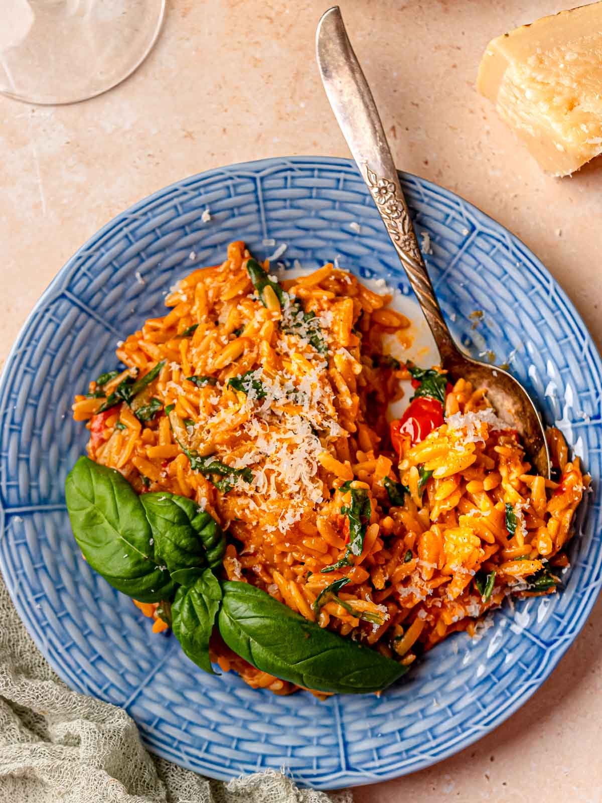 Orzo pasta topped with grated parmesan and fresh basil.