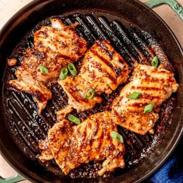 Golden brown grilled chicken thighs with honey mustard marinade on a grill pan.